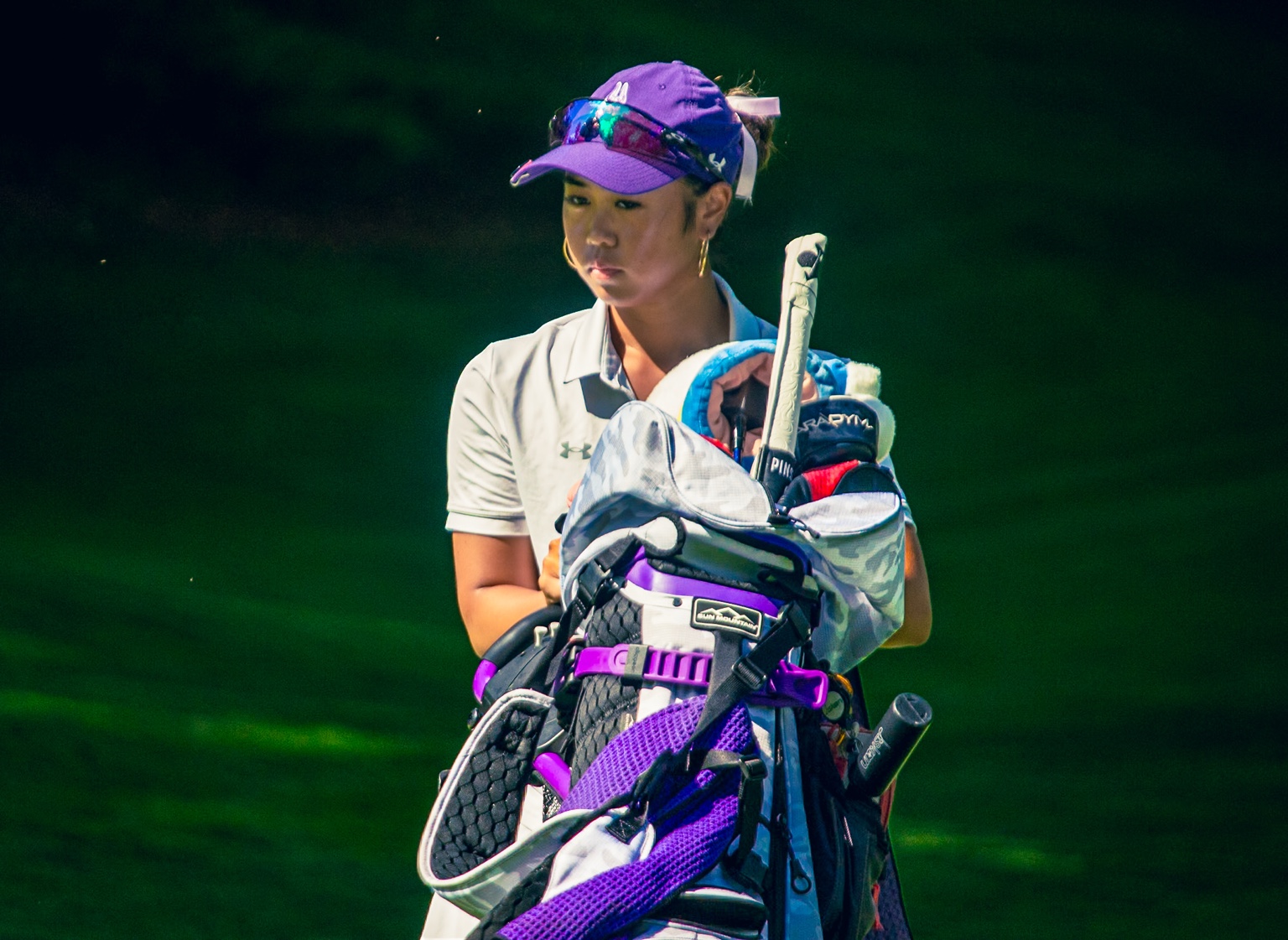 Golfer carrying a golf bag outdoors